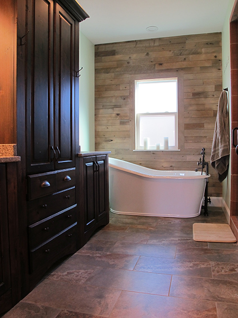 A massive basin style tub completes the master bath featuring floor to ceiling cedar planks and heated stone tiles
